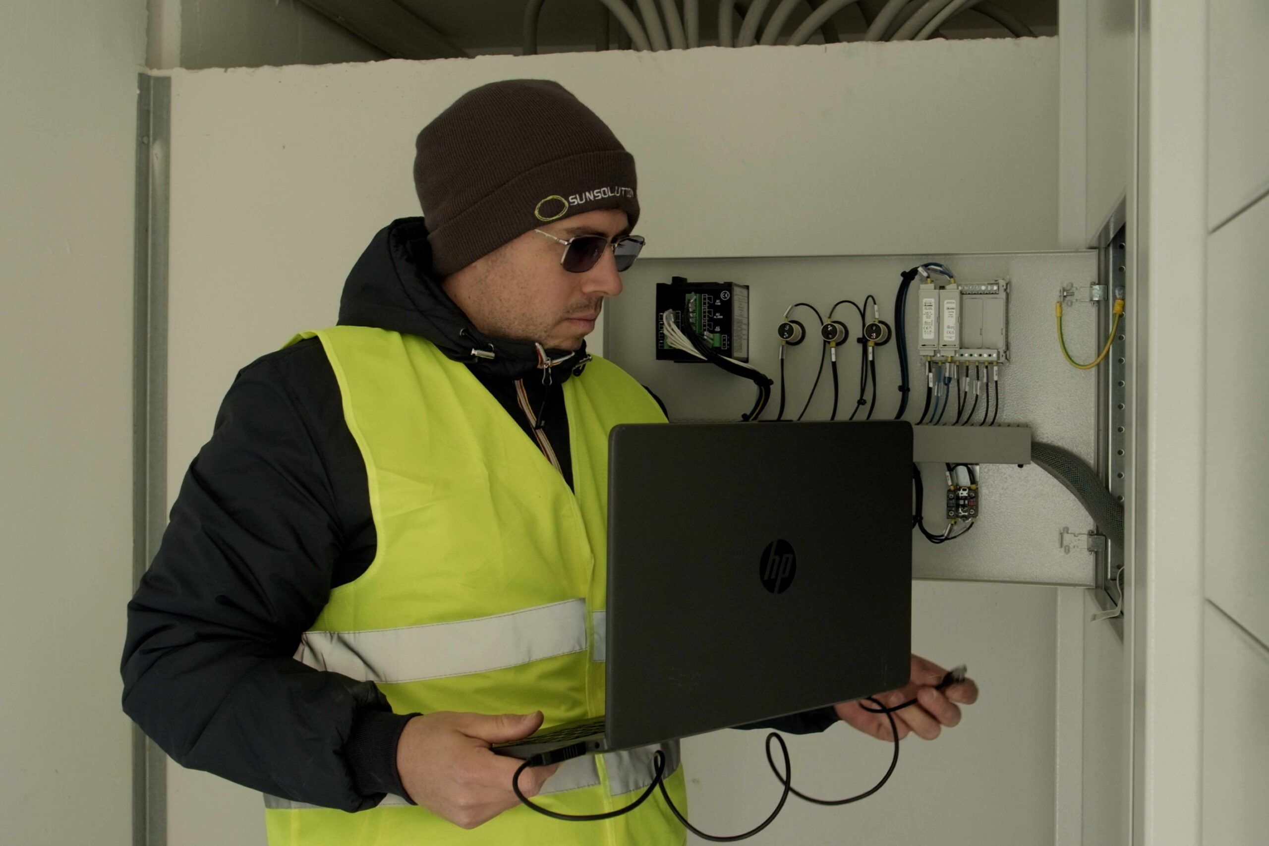 Le mani di un tecnico che sta monitorando il funzionamento dell'impianto fotovoltaico con l'app di monitoraggio su tablet.