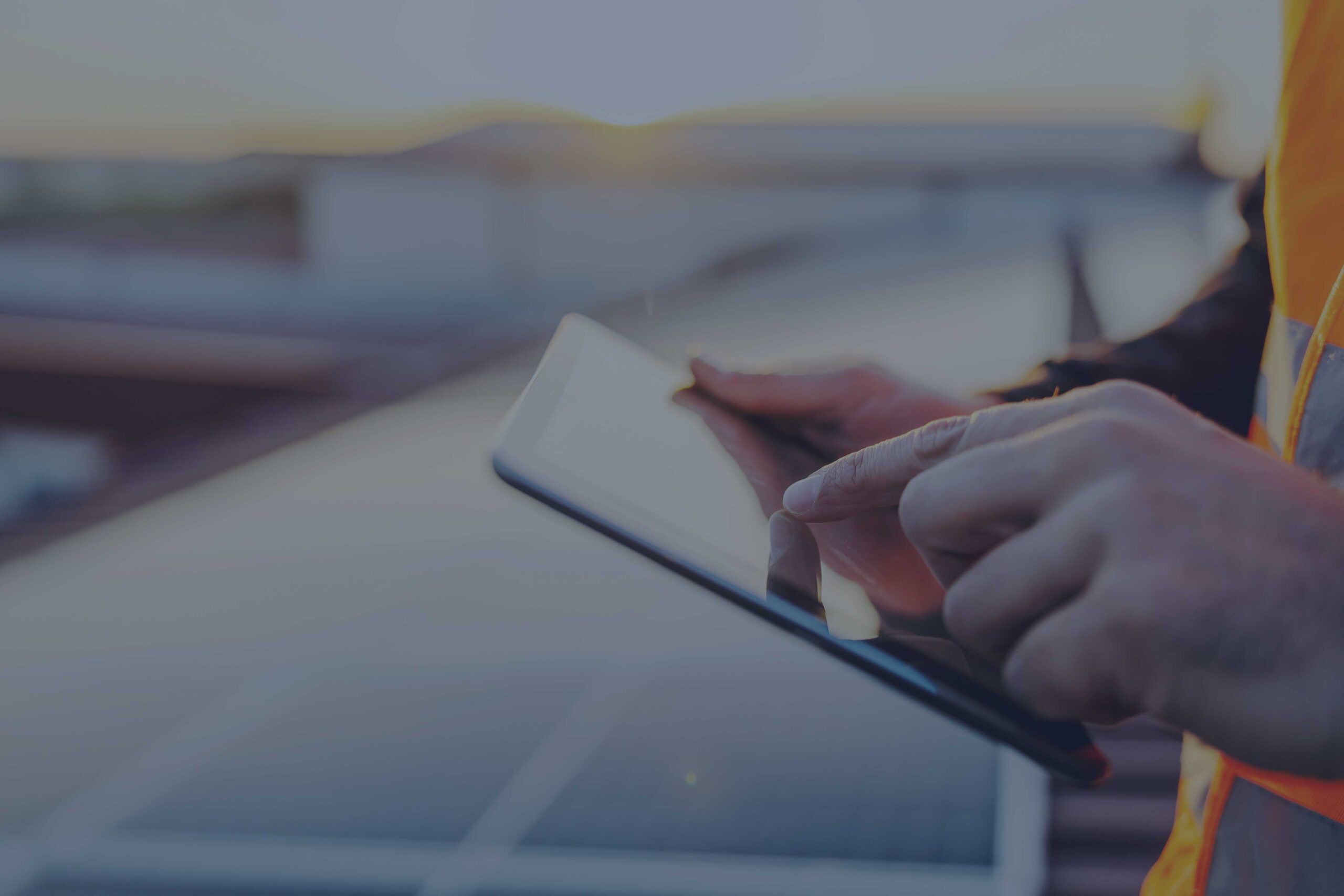 Le mani di un tecnico che sta monitorando il funzionamento dell'impianto fotovoltaico con l'app di monitoraggio su tablet.