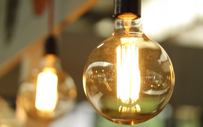 Una lampadina incandescente in primo piano con sullo sfondo un'altra sfocata.